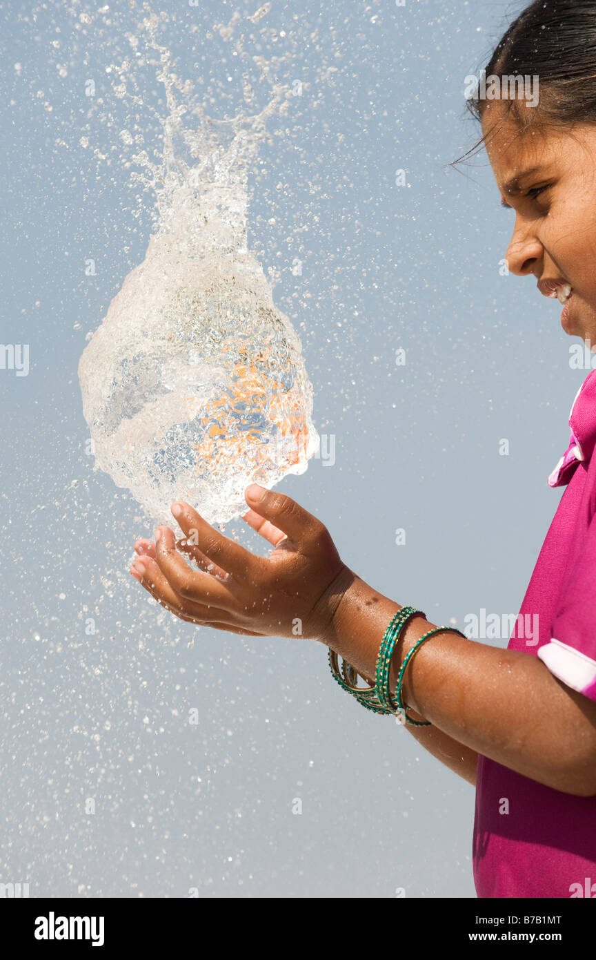 Indian girl attraper un ballon d'eau en rafale. L'Andhra Pradesh. L'Inde Banque D'Images