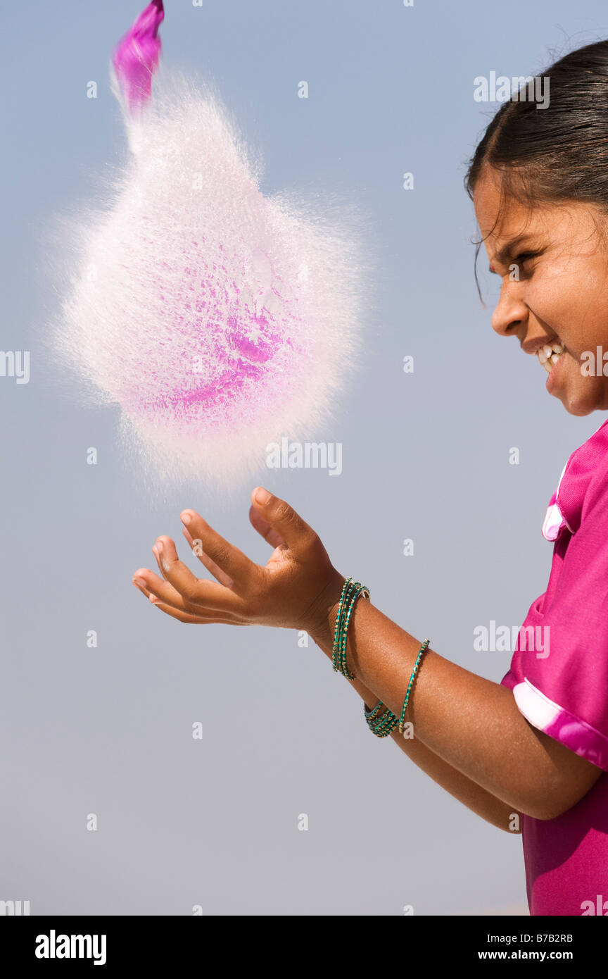 Indian girl attraper un ballon d'eau en rafale. L'Andhra Pradesh. L'Inde Banque D'Images