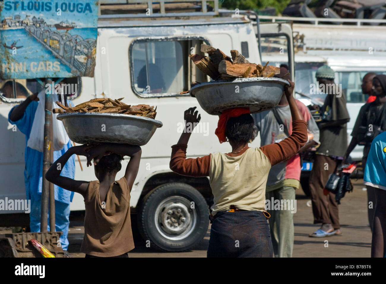 Enfants porteurs de bois de chauffage à la gare routière ou la Gare Routière Pompiers à Dakar au Sénégal Banque D'Images
