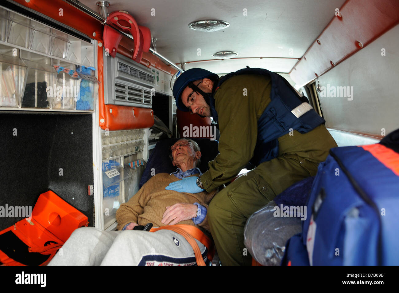 Un militaire paramédical israélien évacue un civil âgé en état de choc après une attaque à la roquette du Qassam palestinien dans la ville d'Ashkelon, en Israël Banque D'Images