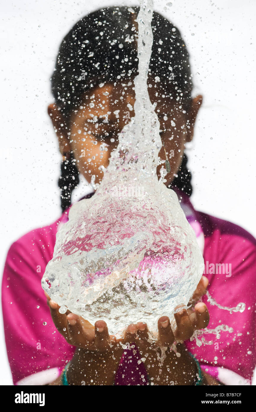 Indian girl attraper un ballon d'eau en rafale. L'Andhra Pradesh. L'Inde Banque D'Images