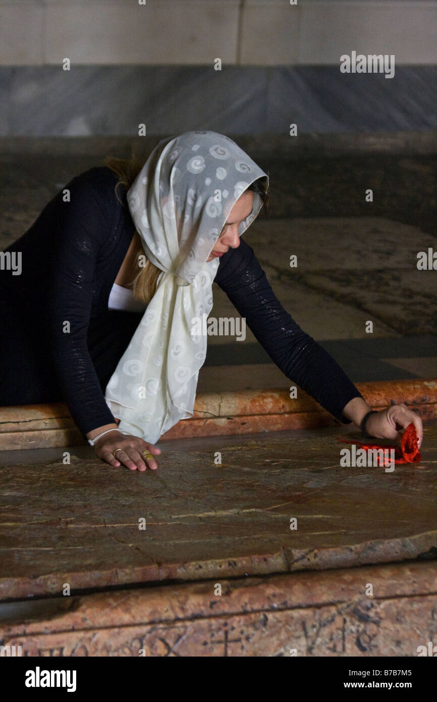 Christian Woman Wiping la pierre de l'Onction dans l'église du Saint-Sépulcre à Jérusalem Banque D'Images