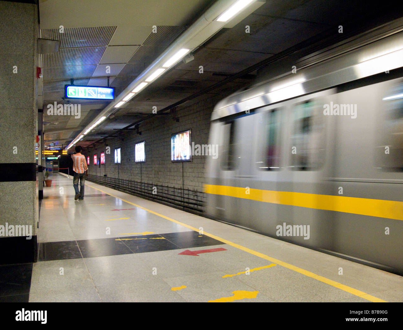 Une ligne jaune train s'éloigne de la plate-forme sur la Delhi Metro Rail system. Delhi. L'Inde. Banque D'Images