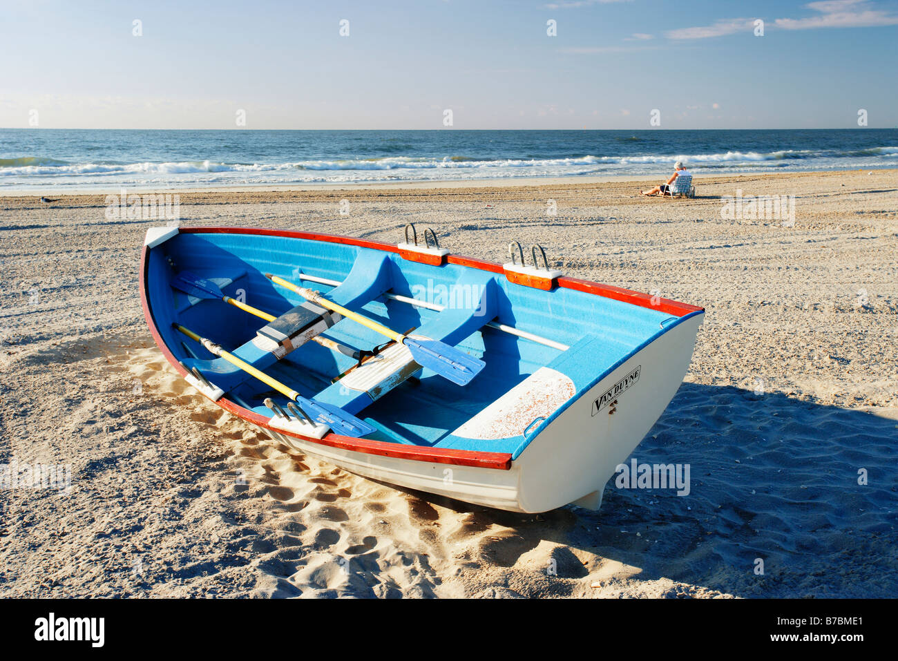Homme mûr en arrière-plan assis sur plage et petit bateau, New Jersy, USA Banque D'Images