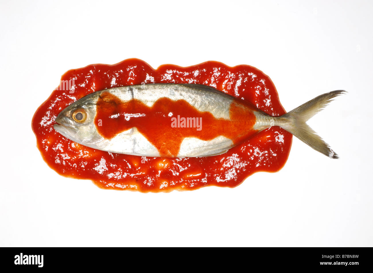 Un petit poisson entier avec red hot sauce épicée Banque D'Images