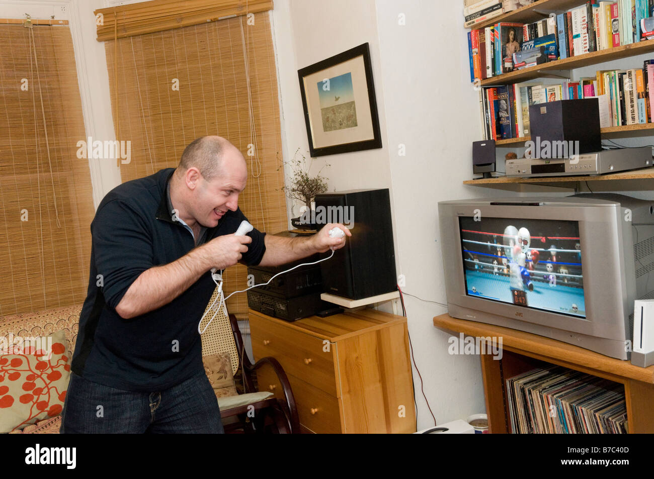 L'homme jouant sur une console de jeux Nintendo Wii, England UK Banque D'Images