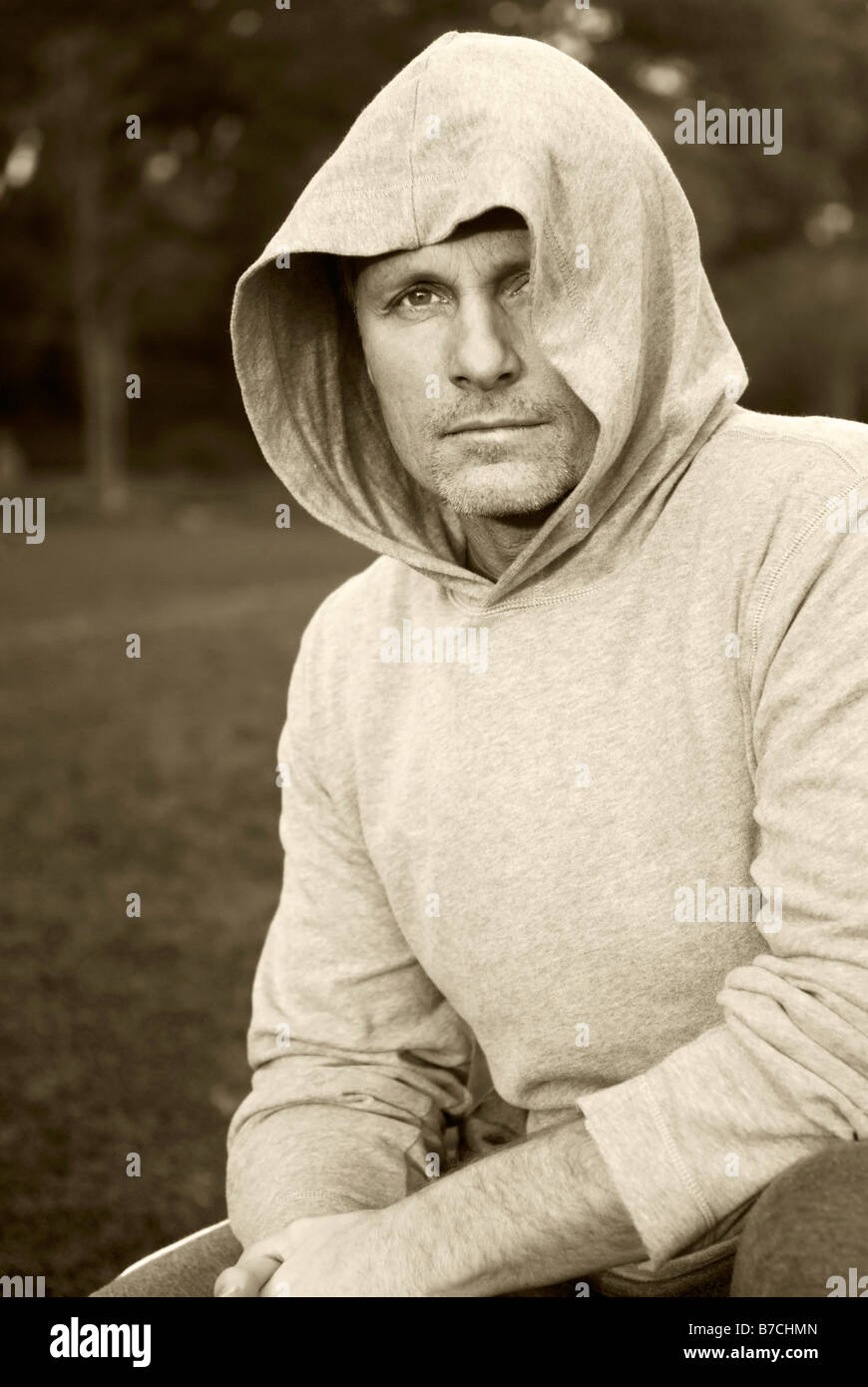 Le portrait d'une pensive à la quarantaine homme portant un haut à capuchon. Banque D'Images