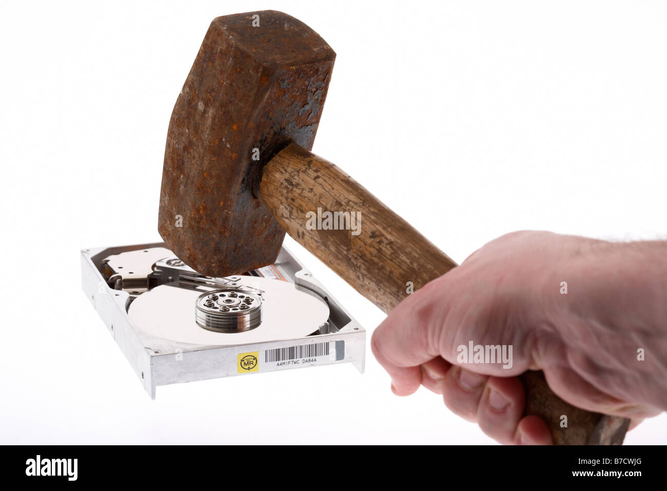 Mans hand holding vieux marteau de plus d'un disque dur de l'ordinateur sur fond blanc Banque D'Images