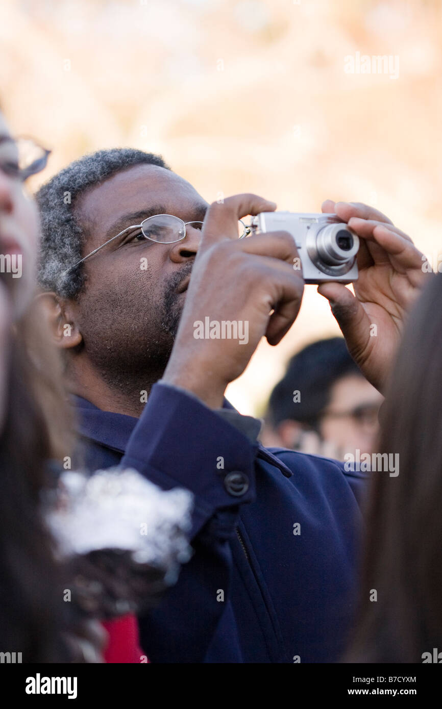 Un homme noir prend une photo avec un appareil photo compact à l'inauguration qui a eu lieu à l'Université de Californie, Berkeley Banque D'Images