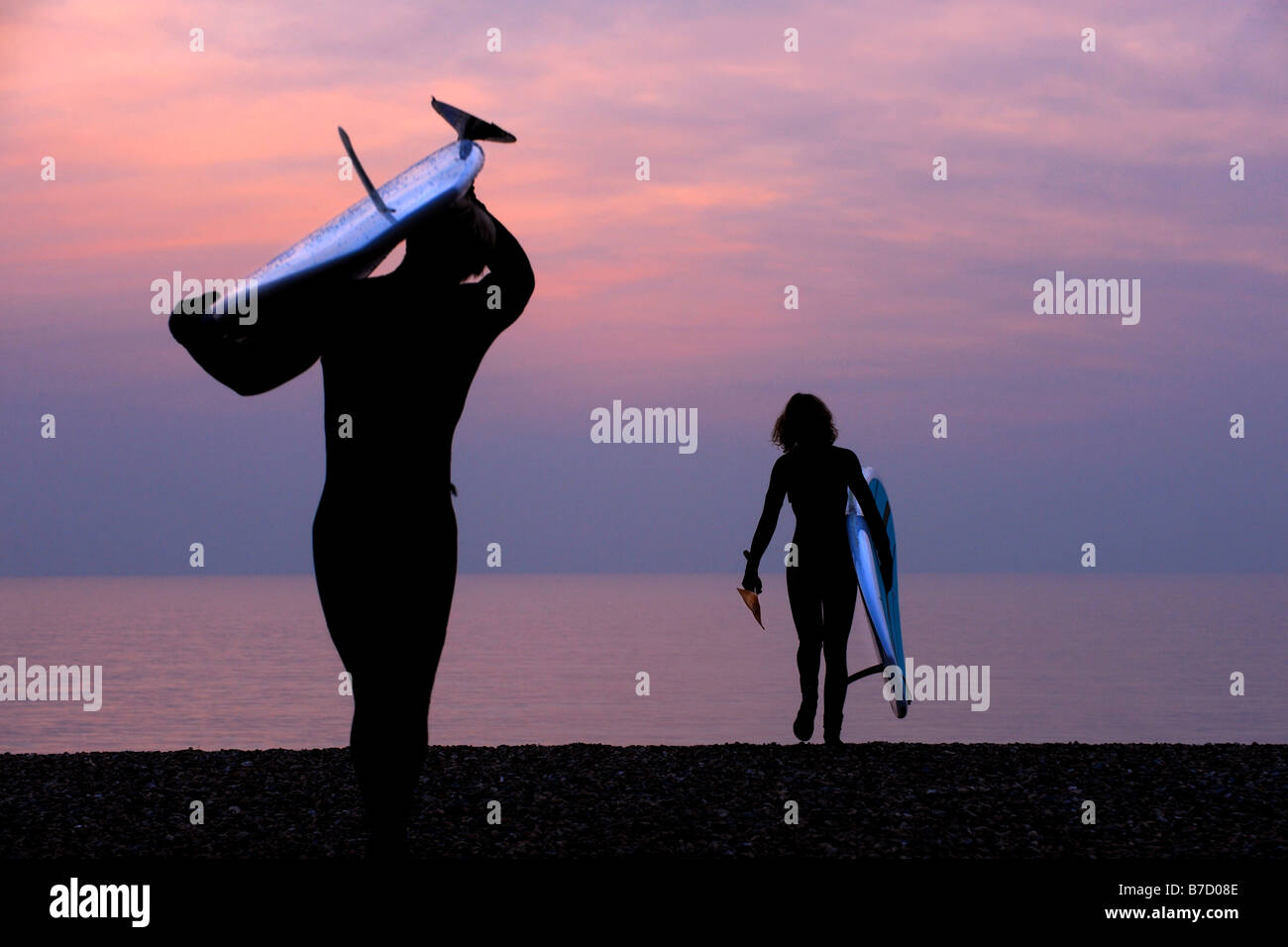 Surfers portent leurs conseils à la plage et prendre le dernier jour de l'hiver au large de Brighton dans l'East Sussex. Photo par Jim Holden Banque D'Images