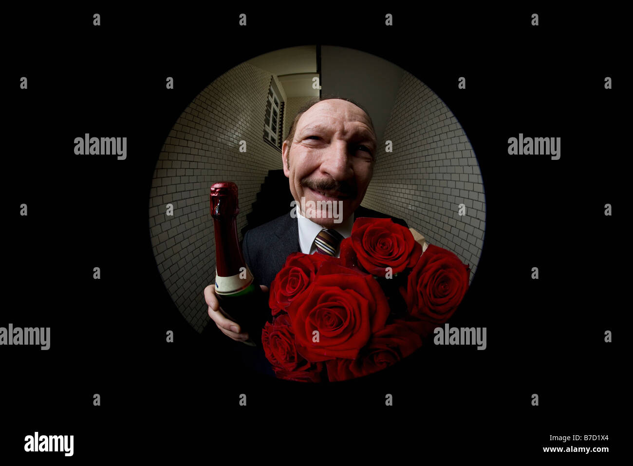 Un homme avec des roses et du champagne vu à travers un judas Banque D'Images