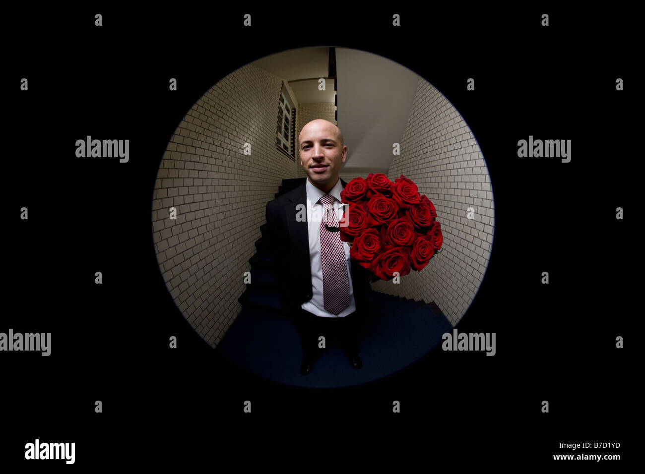 Un homme avec un bouquet de roses à travers judas Banque D'Images