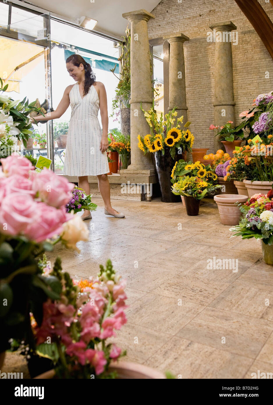 Femme debout à l'intérieur d'un magasin de fleur Banque D'Images