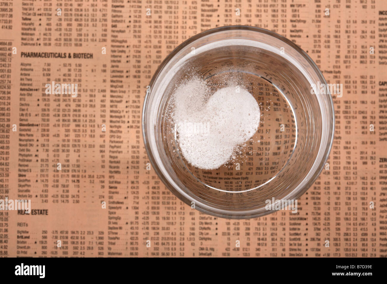 Deux comprimés d'aspirine paracétamol soluble dans un verre d'eau sur un exemplaire du Financial Times Banque D'Images