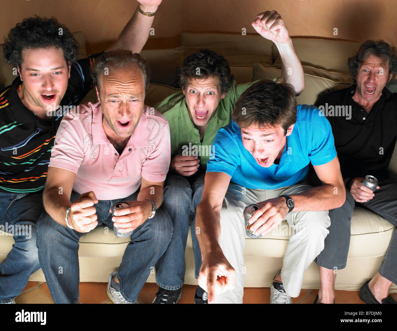 Les hommes à regarder la télévision, holding beers Banque D'Images