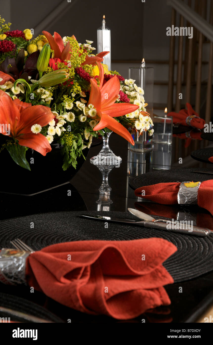 Dîner d'automne de table avec des serviettes rouges et de fleurs sur fond noir Banque D'Images