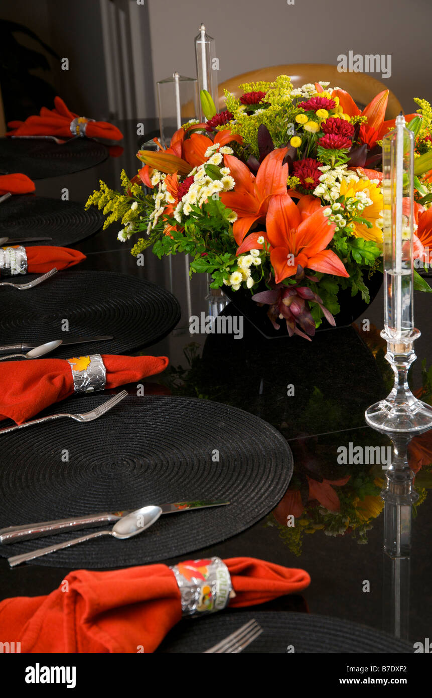 Un ensemble de tables de granit noir d'avoir un dîner de Thanksgiving avec tapis et serviettes de table rouge noir Banque D'Images