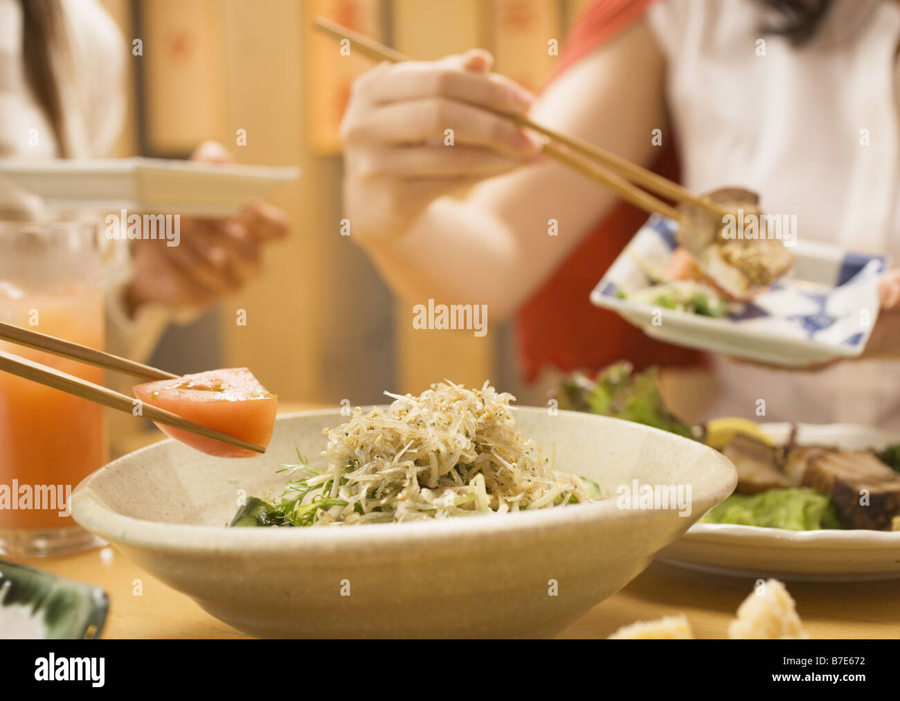 Les personnes ayant avec des baguettes Salade Banque D'Images