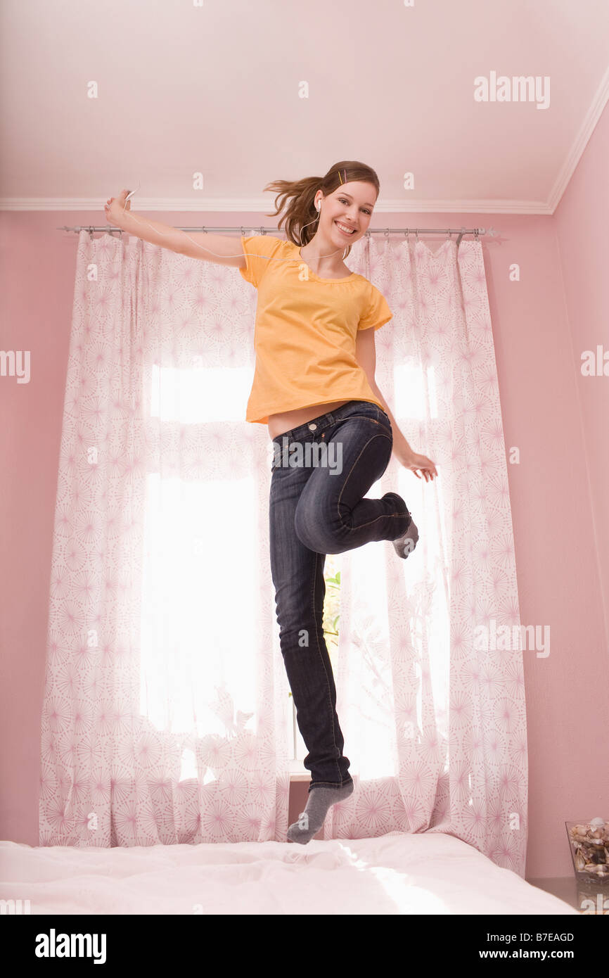 Une adolescente de sauter sur son lit Banque D'Images