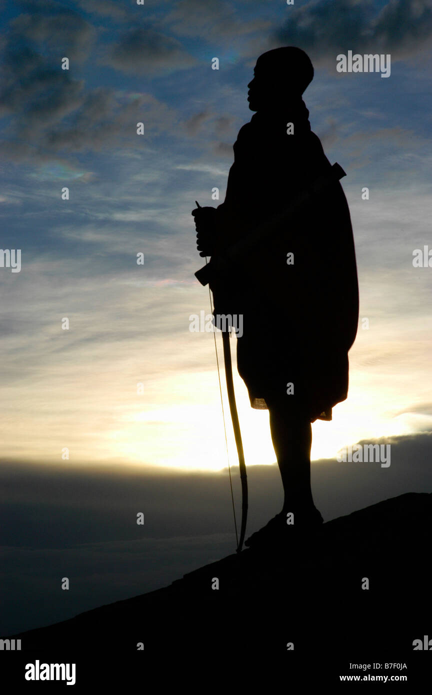 Silhouette d'un guerrier Massaï avec vue sur les plaines du Serengeti en Tanzanie Banque D'Images