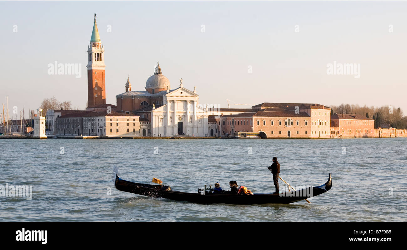 Une gondole à Venise passe l'île de San Giorgio Maggiore avec son église du même nom en début de soirée Banque D'Images