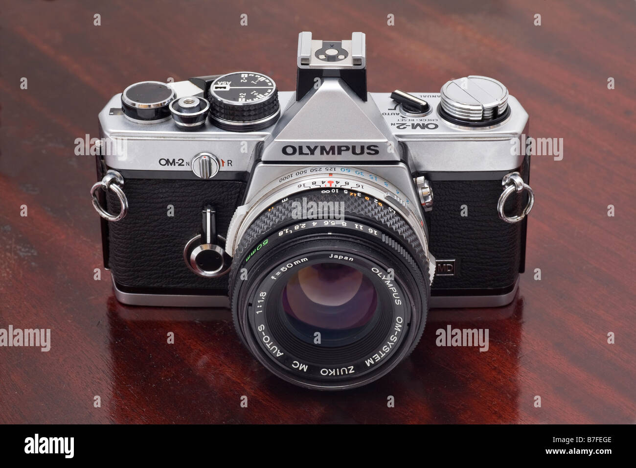 Olympus OM2n single lens reflex caméra 35mm avec 50 mm f1 8 de l'objectif Zuiko fond darkwood Banque D'Images