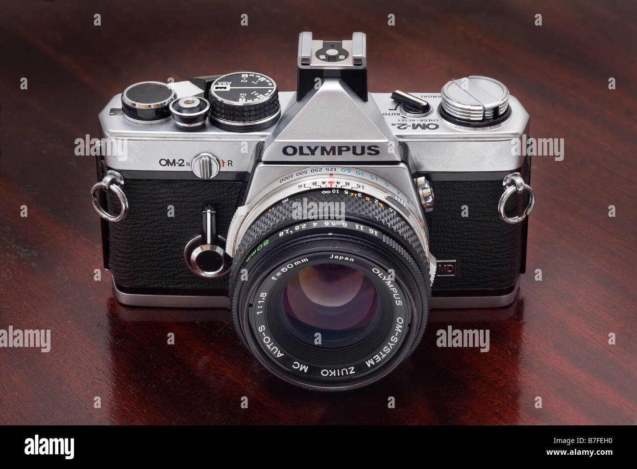 Olympus OM2n single lens reflex caméra 35mm avec 50 mm f1 8 de l'objectif Zuiko fond darkwood Banque D'Images