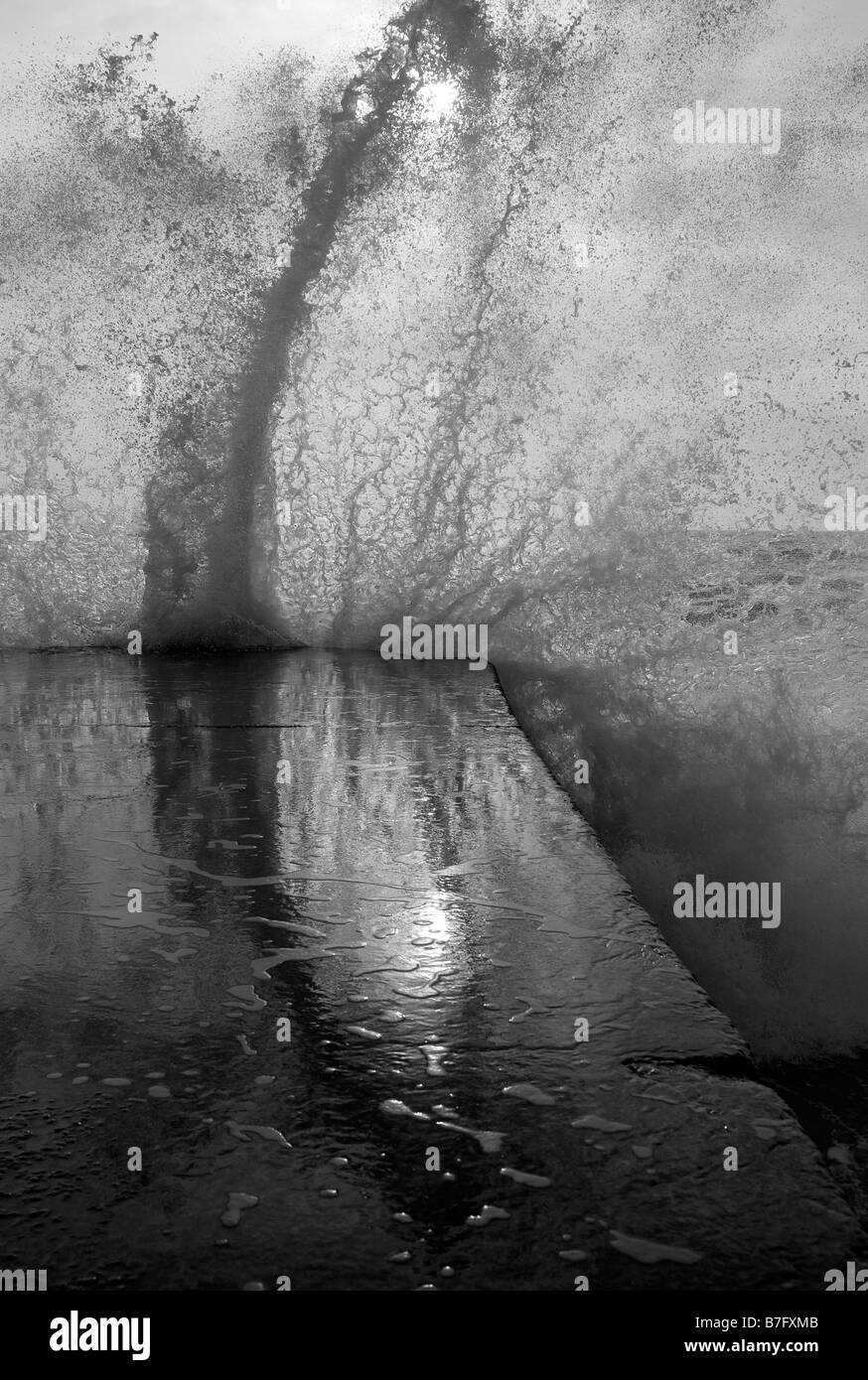 Close-up du déferlement des vagues sur le béton épi, la plage de Brighton, l'hiver. Banque D'Images