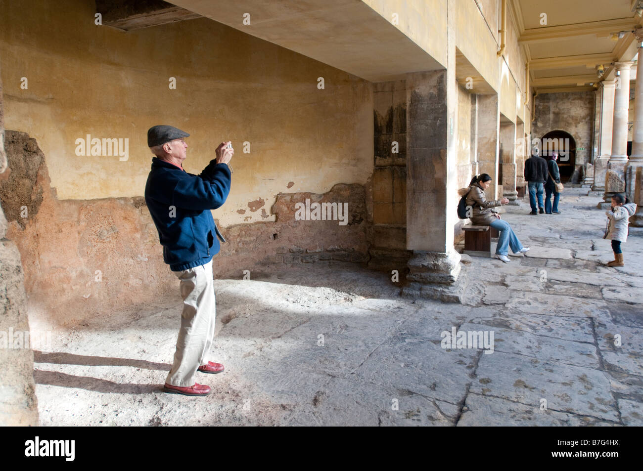 Un touriste aux bains romains de Bath, Royaume-Uni de prendre une photo Banque D'Images