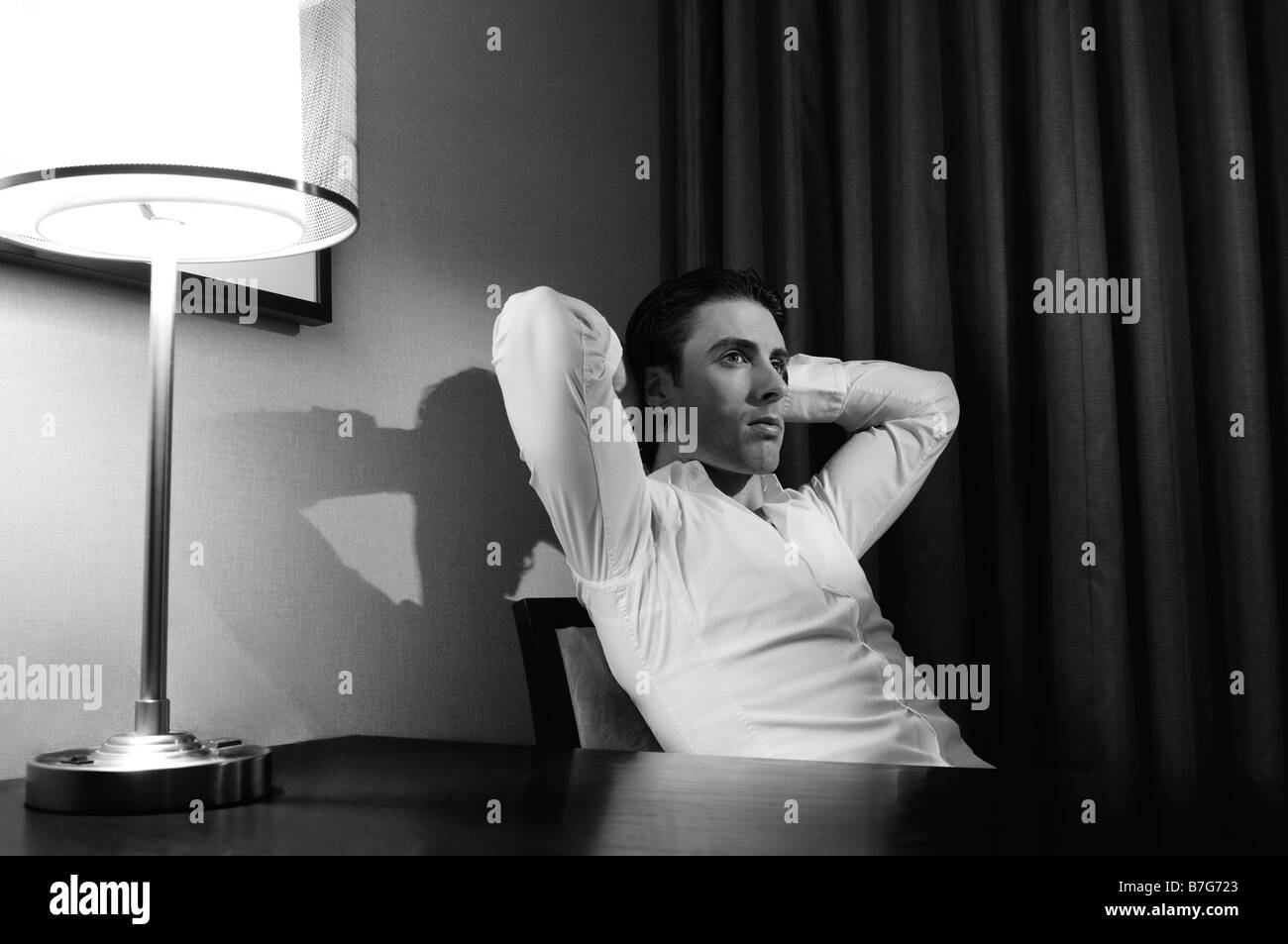 Jeune homme assis à un bureau Banque D'Images