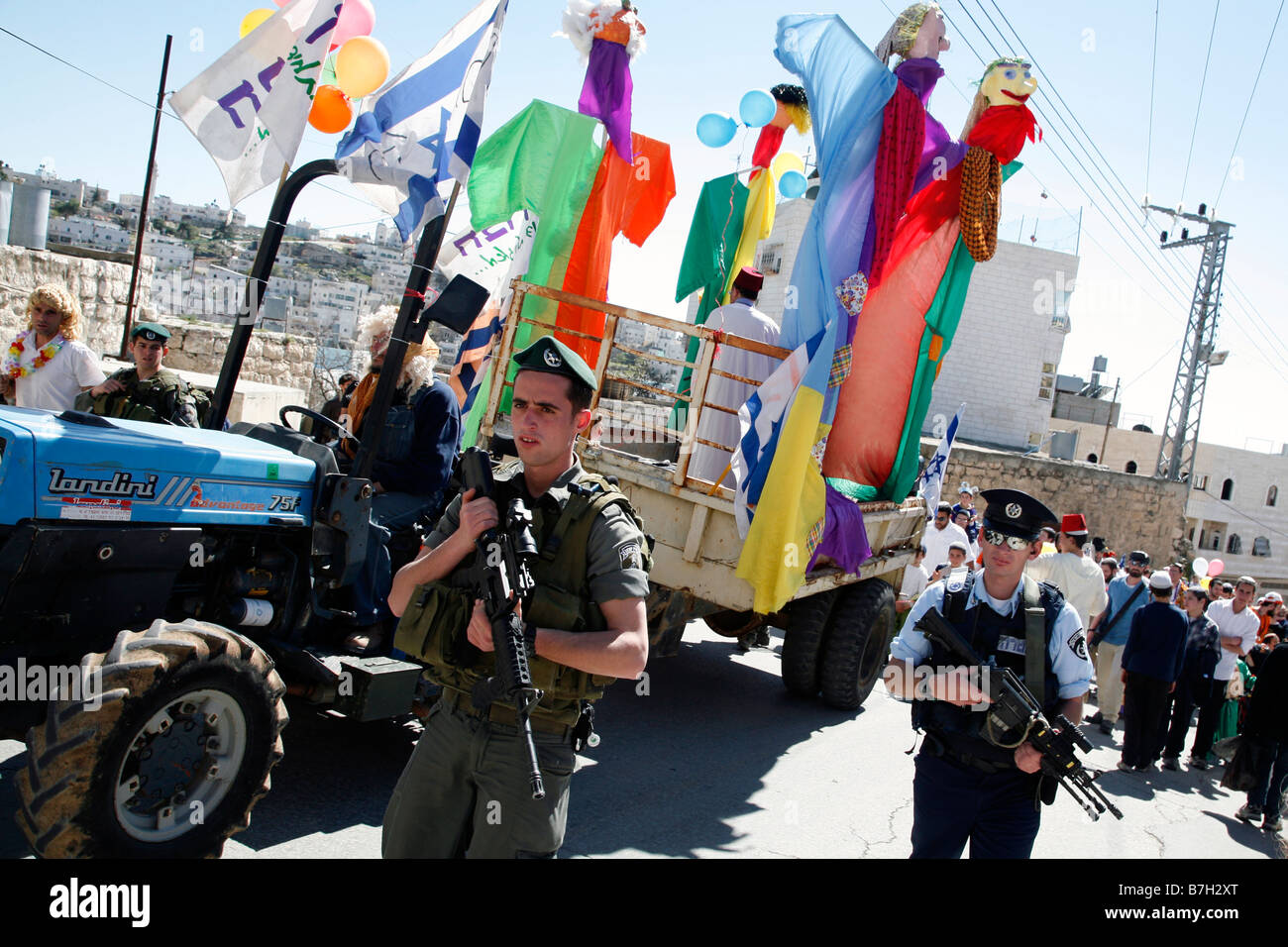 La police israélienne l'escorte d'un flotteur au cours d'une célébration de Pourim dans la vieille ville occupés par Israël des territoires palestiniens d'Hébron. Banque D'Images