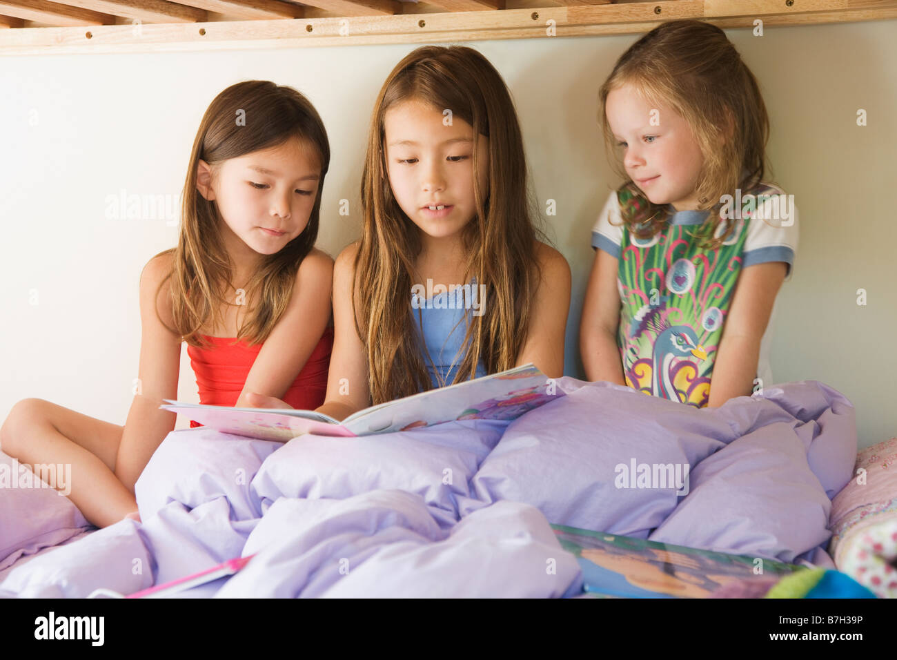 Les jeunes filles lecture histoire sur lit superposé Banque D'Images