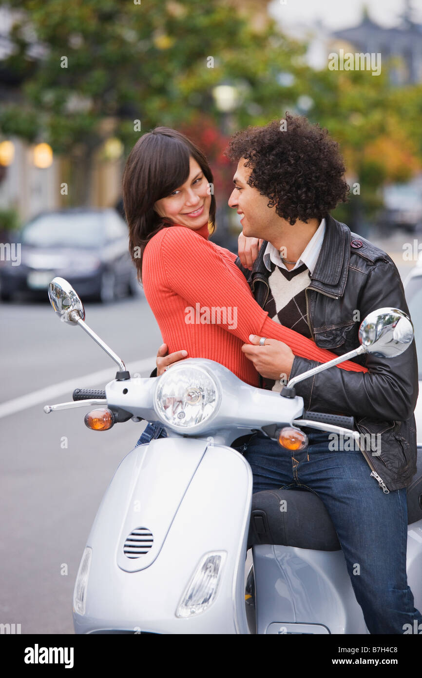 Couple sitting on scooter Banque D'Images