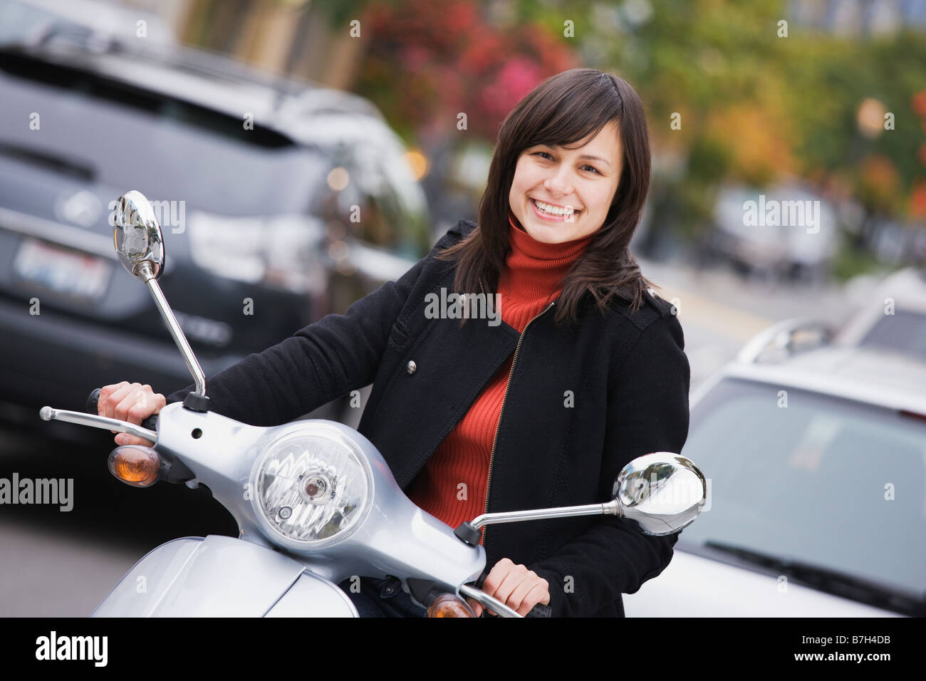 Mixed Race woman driving scooter Banque D'Images