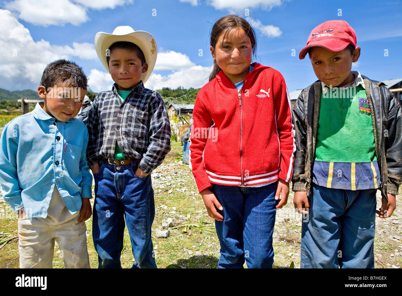 Trois garçons et une fille poser près d'une église à San Nicolas hautes terres de l'ouest du Guatemala Banque D'Images