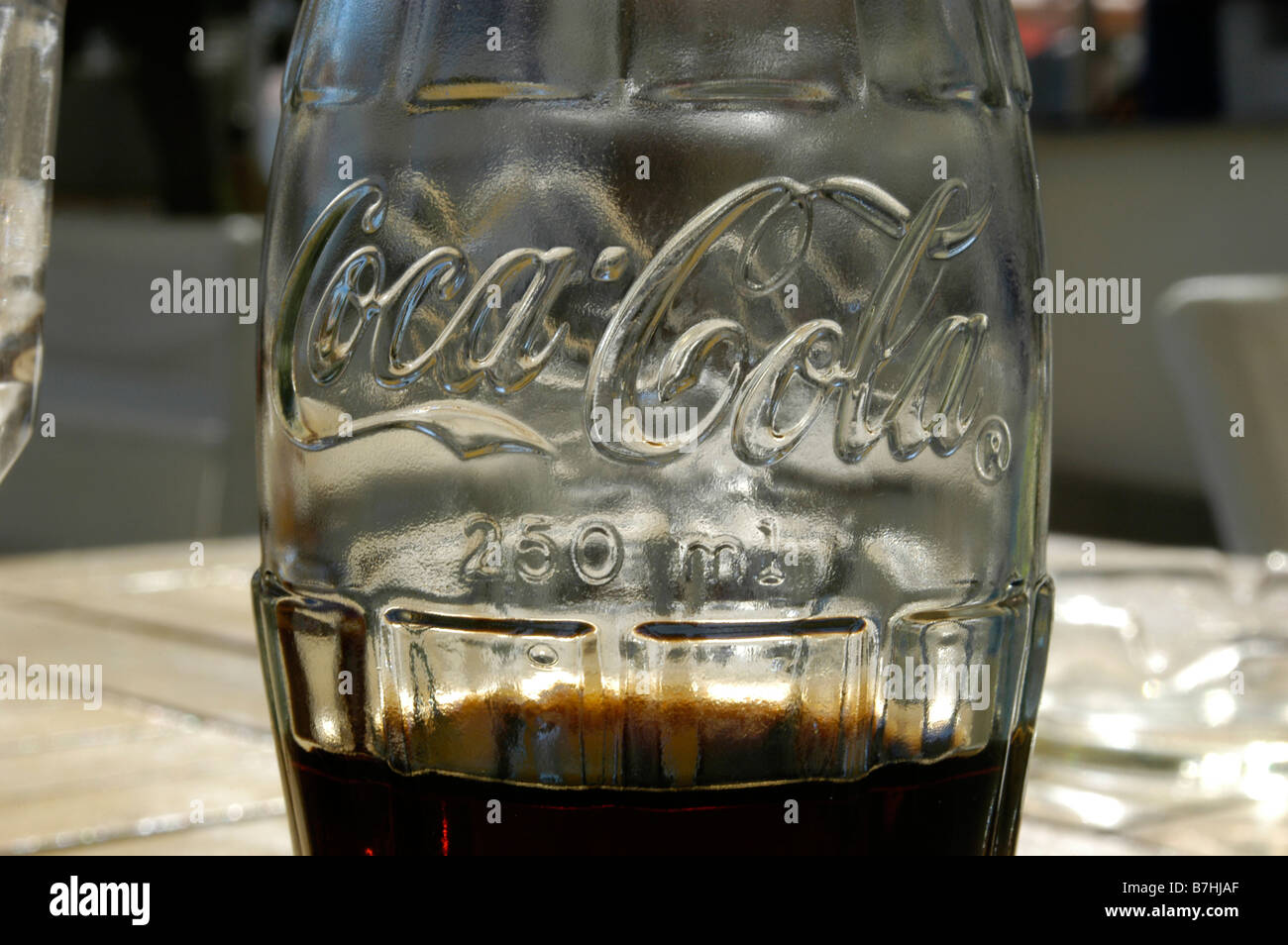 Détail d'une bouteille de Coca-Cola sur une table en bois Banque D'Images