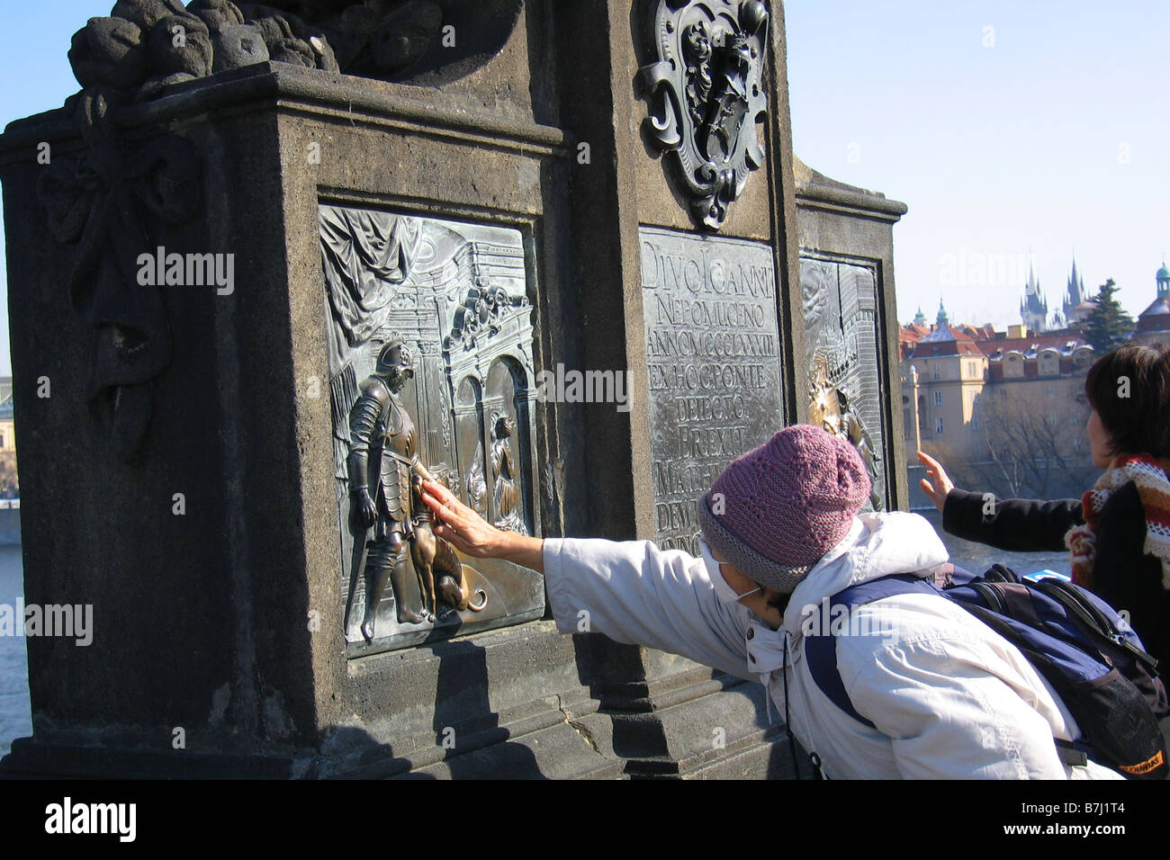 Un touriste japonais touche la St Jean sur plaque en laiton, le Pont Charles, Prague, République Tchèque Banque D'Images