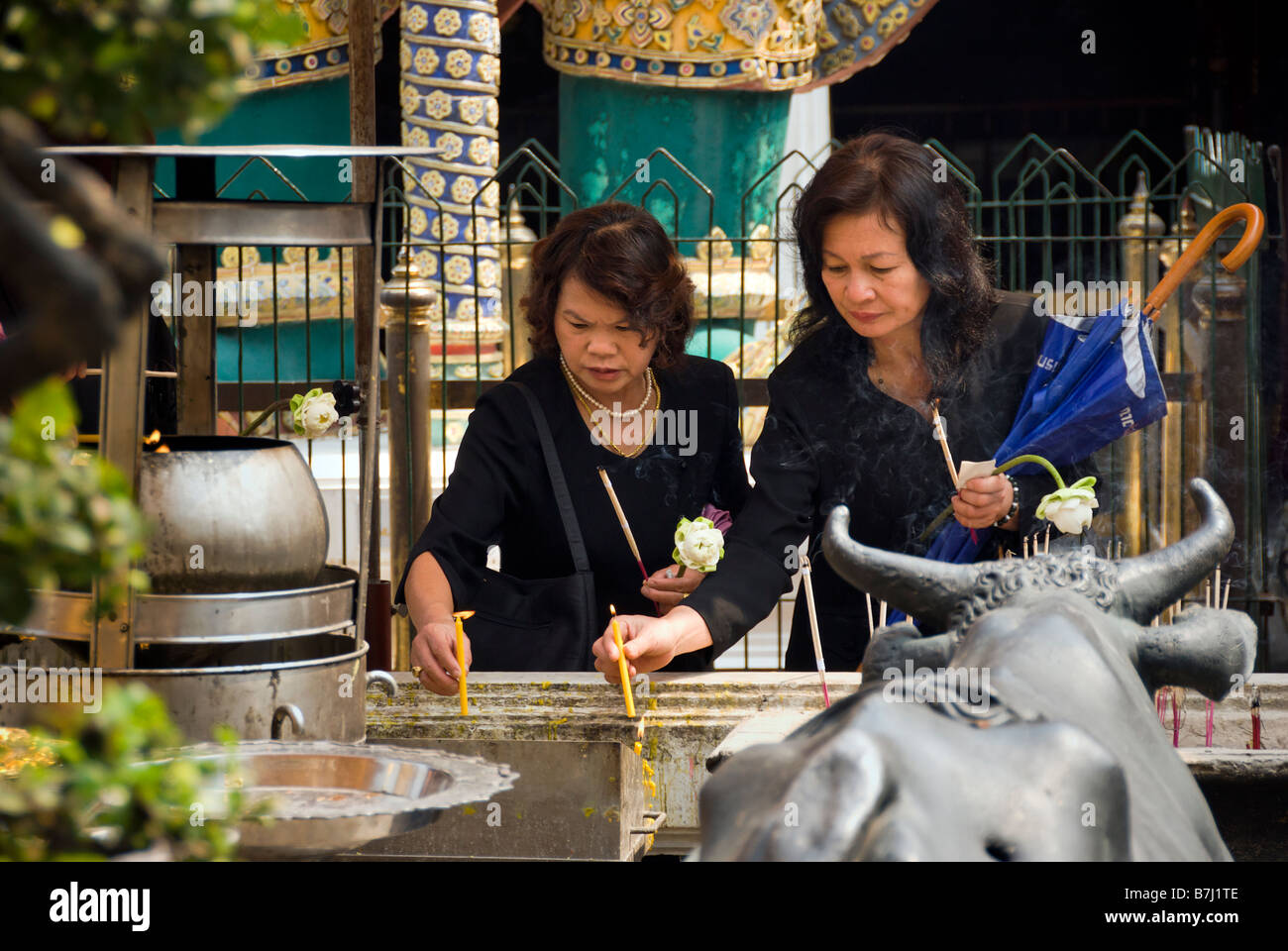 Les femmes thaïlandaises bougies d'éclairage - Wat Phra Kaew et le Grand Palais dans le centre de Bangkok en Thaïlande Banque D'Images