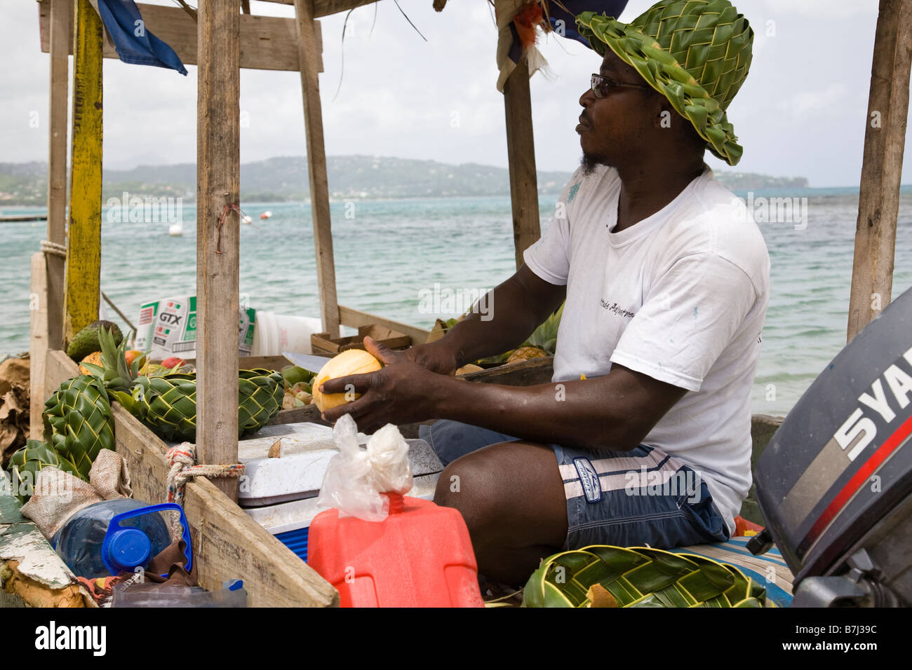 Un vendeur de fruits fruits prépare à la vente de son bateau, St Lucie, West Indies. Banque D'Images