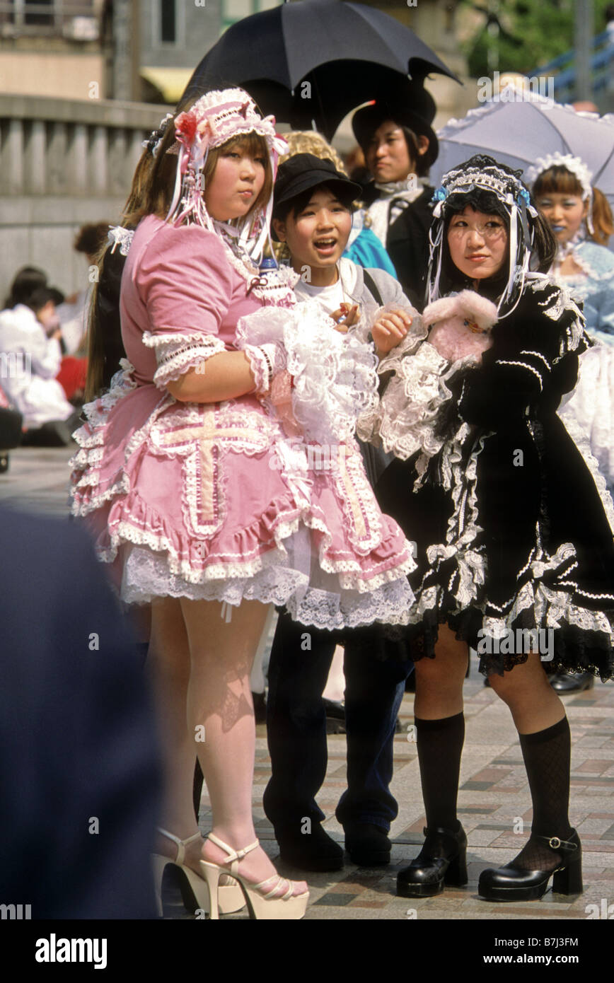 Les jeunes filles en costumes regarder d'autres vêtements de mode à Harajuku Japon Tokyo district Banque D'Images