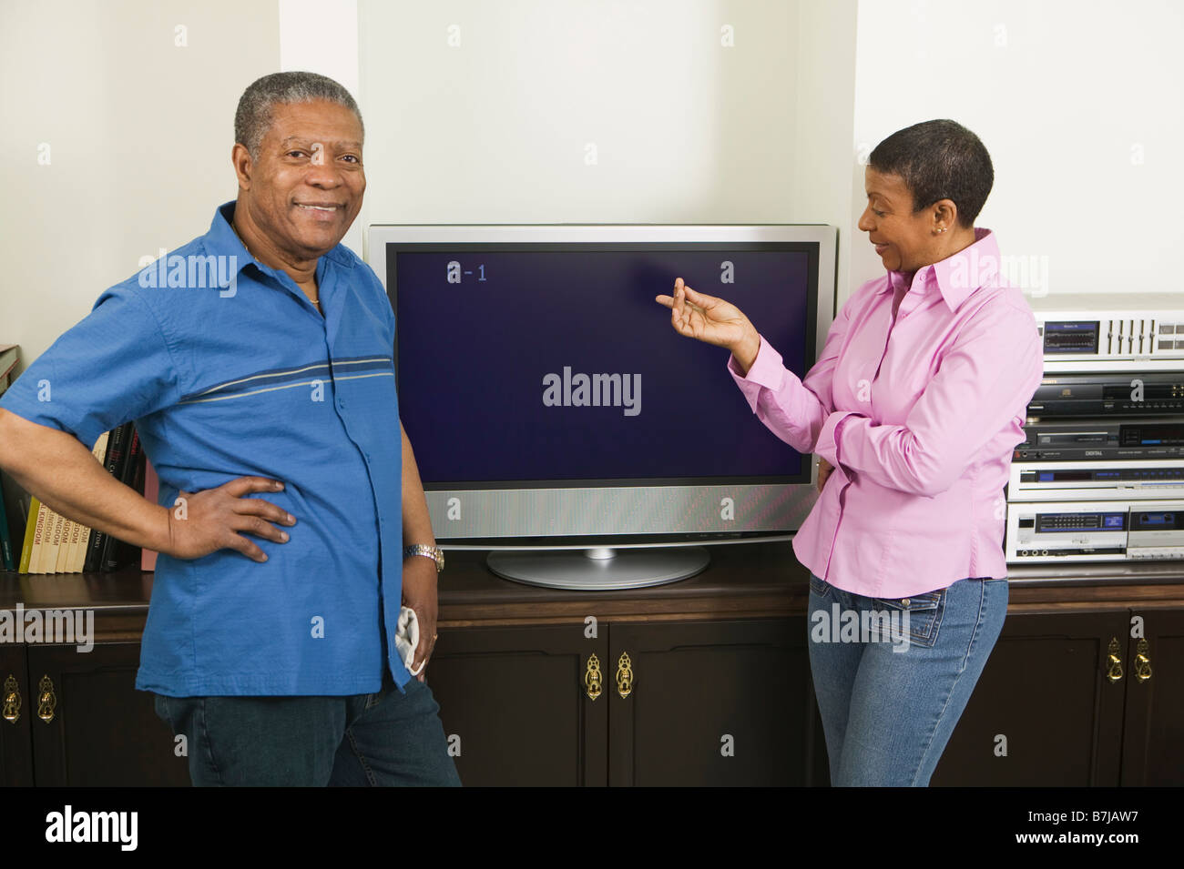 African American couple l'installation d'une télévision écran plat, Vancouver, C.-B. Banque D'Images