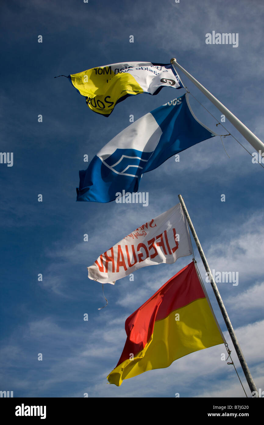 Lifeguard drapeaux et drapeau bleu Prix de la qualité de l'eau au-dessus de la plage de Port Eynon Gower Banque D'Images