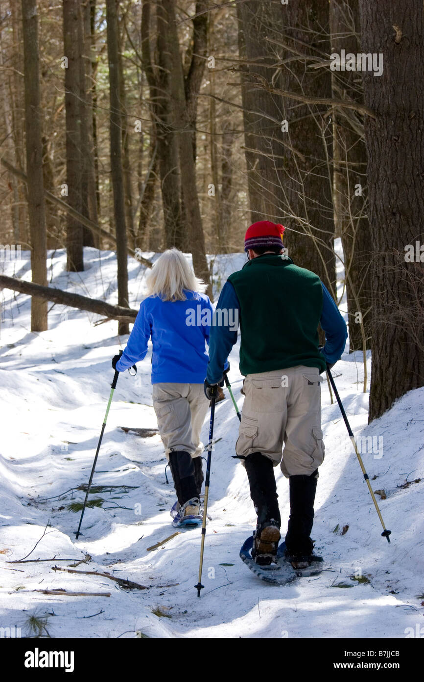 Un homme et une femme de la raquette sur une journée d'hiver ensoleillée dans le New Hampshire Banque D'Images