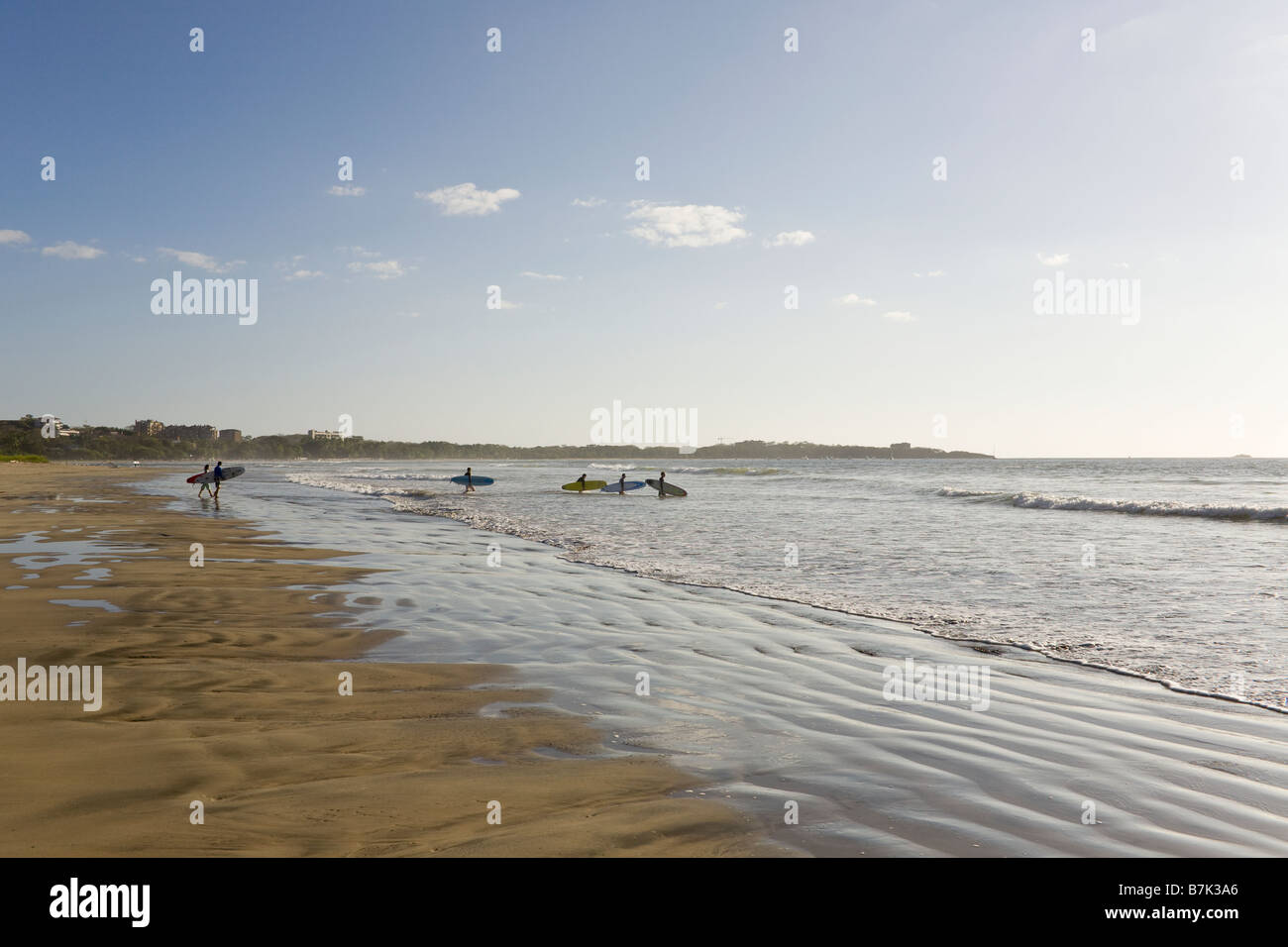 Balades dans les vagues de Surfers à Playa Grande, le Costa Rica. Banque D'Images