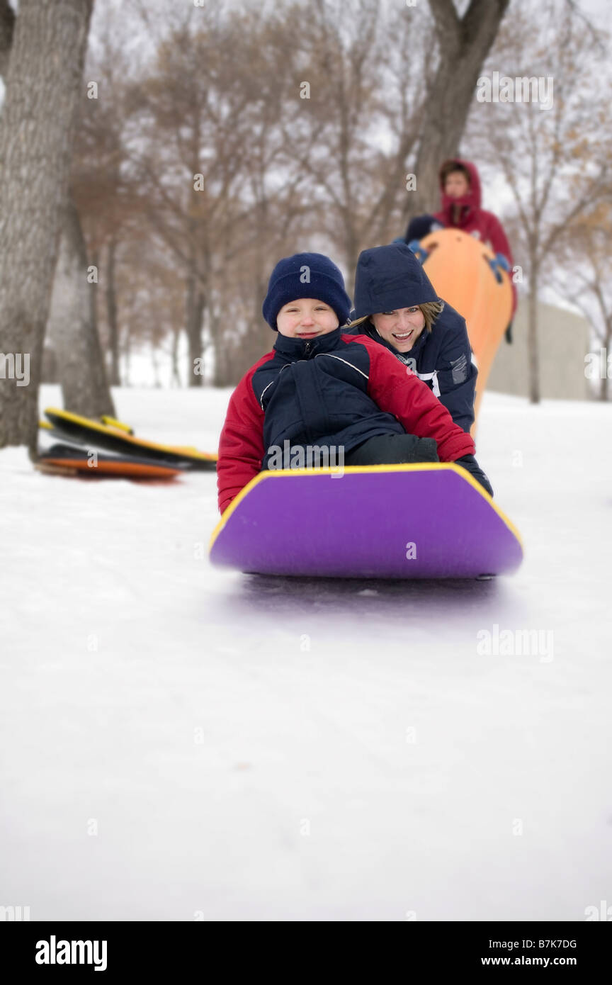 Gril pousse un autre enfant sur le toboggan, Regina, Saskatchewan, Canada Banque D'Images