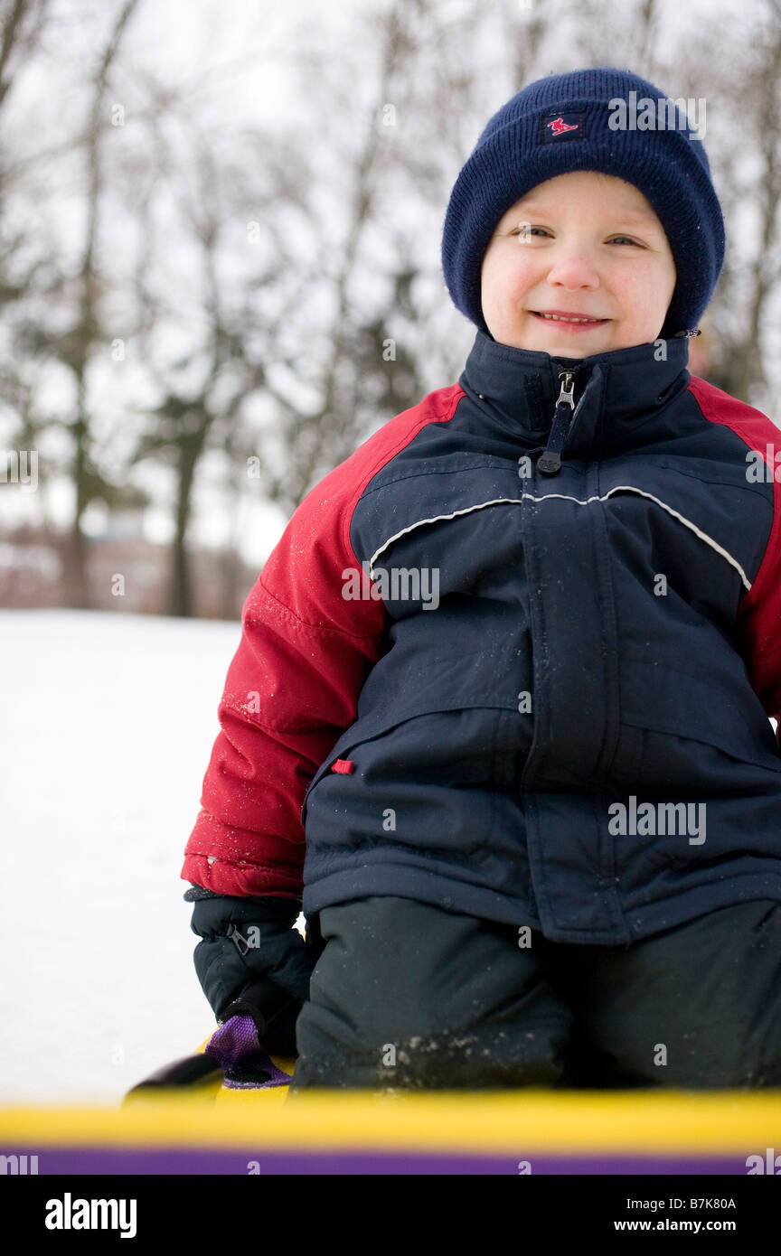 Enfant sur la neige slider, Regina, Saskatchewan, Canada Banque D'Images