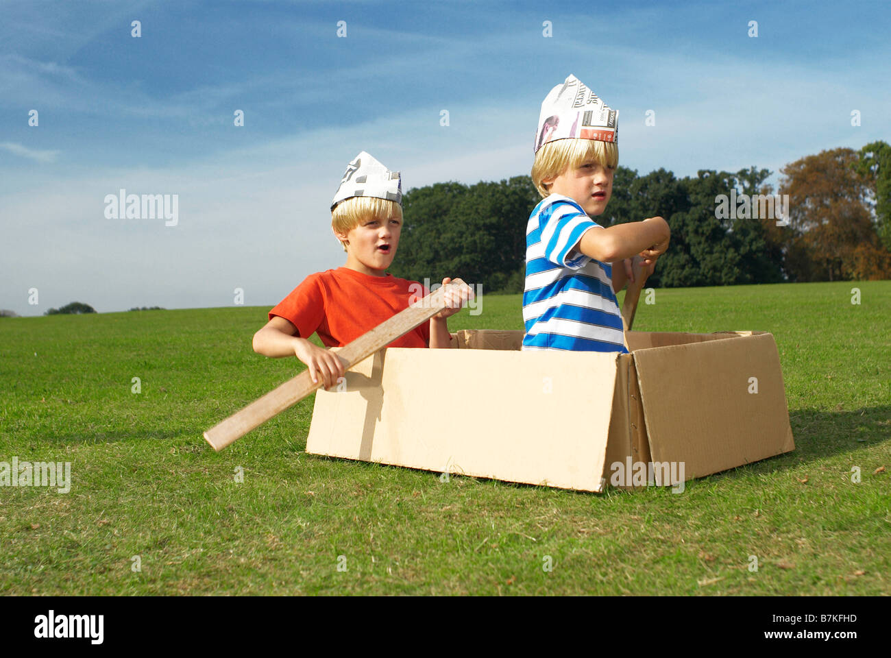 Les garçons à l'aide de boîte comme bateau imaginaire Banque D'Images