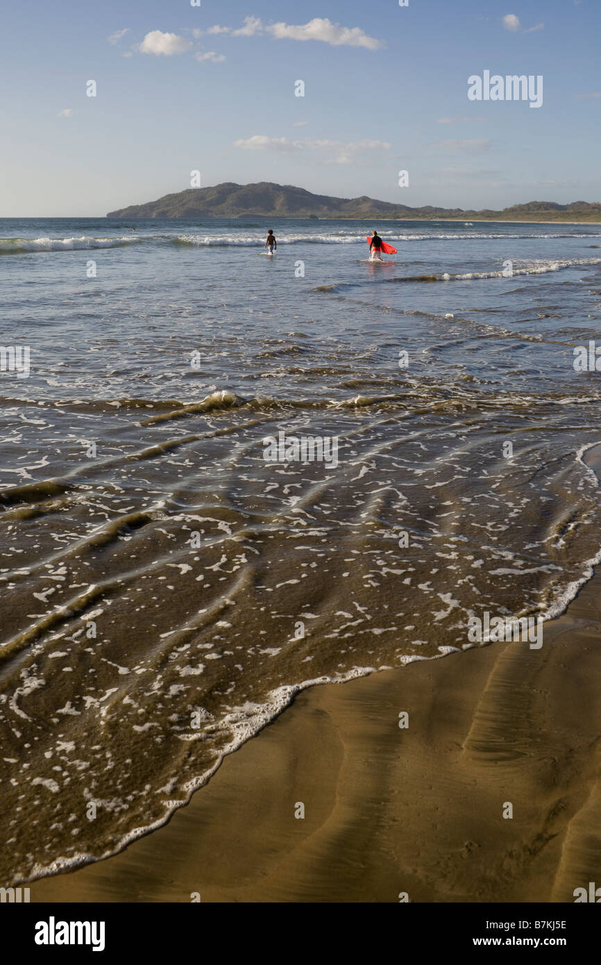 Surfers dans le surf à Playa Grande, le Costa Rica. Banque D'Images