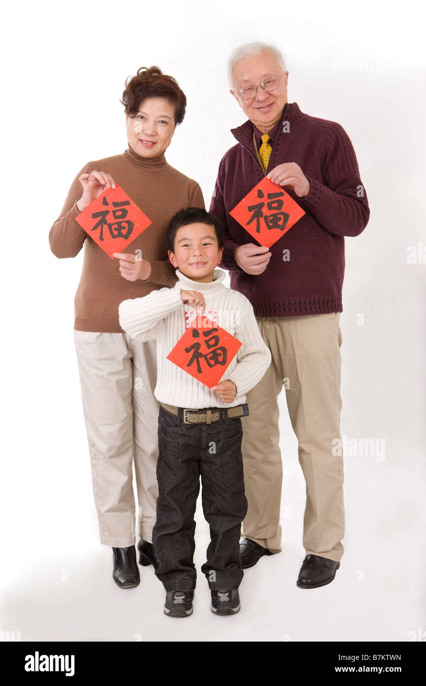 Couple de personnes âgées avec little boy holding scripts chinois et smiling at the camera Banque D'Images