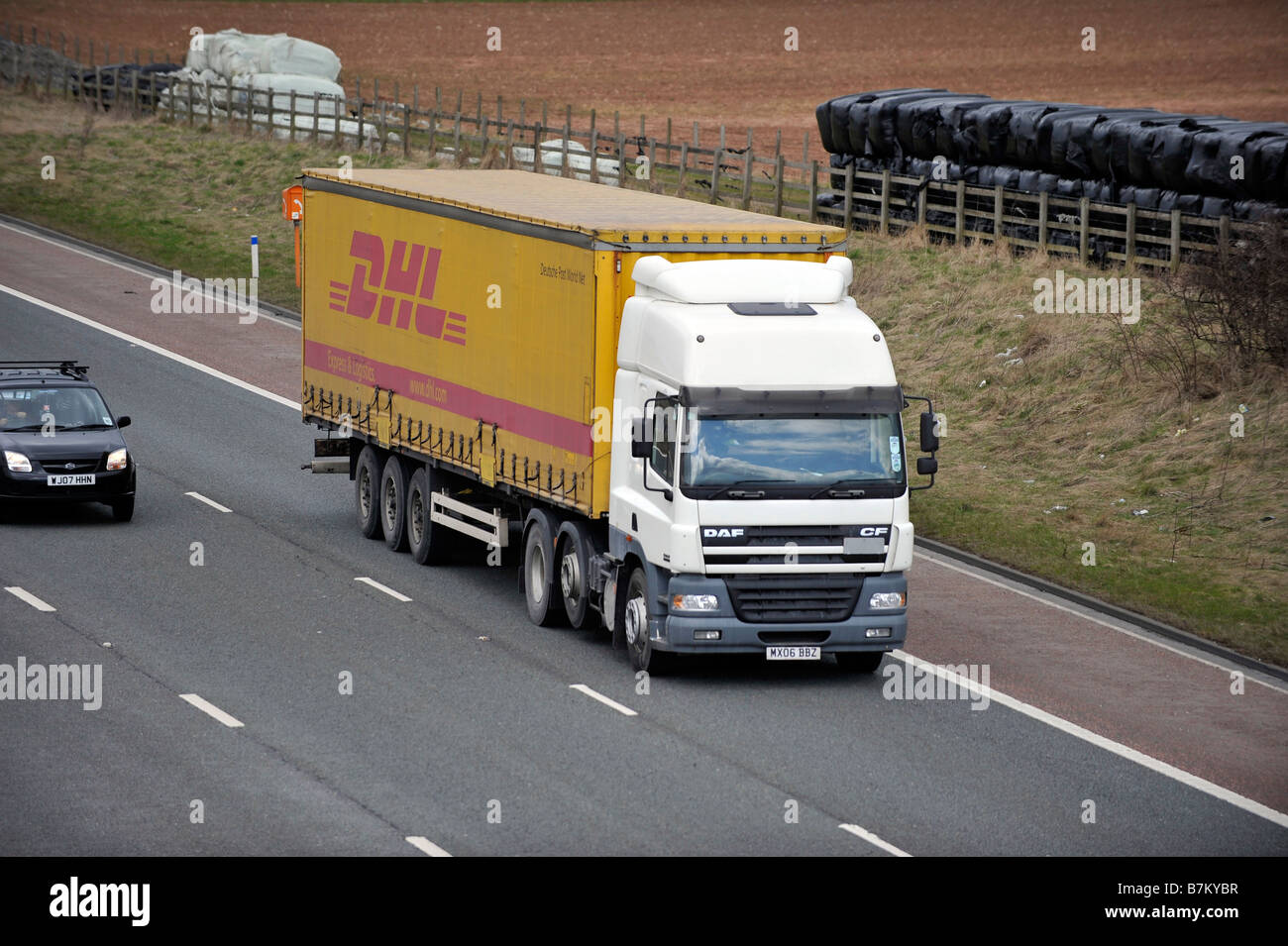 DAF CF85 trois essieux camion avec remorque à essieu tri curtainsided DHL sur autoroute Banque D'Images DAF CF85 trois essieux camion avec remorque à essieu tri curtainsided DHL sur autoroute Banque D'Images